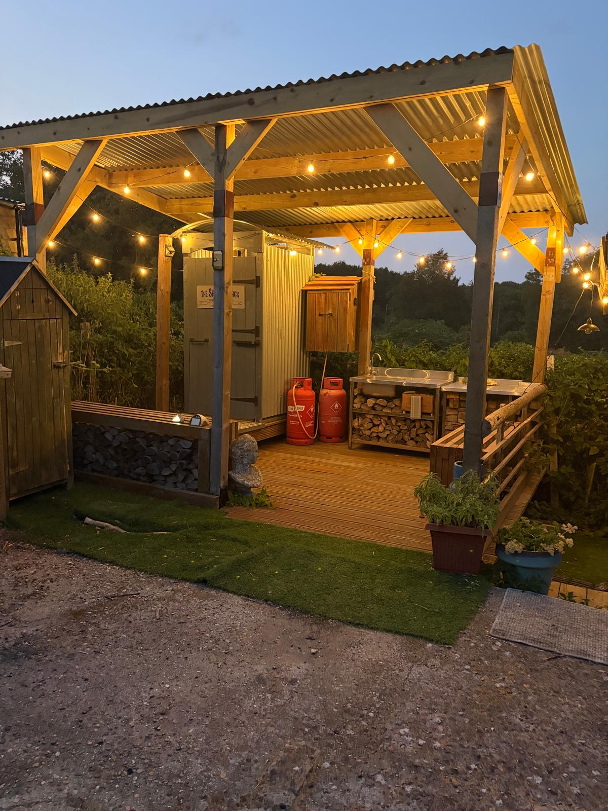 The Shower Shack on the deck at dusk, with fairy lights